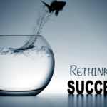 Fish jumping out of a fishbowl to represent rethinking success