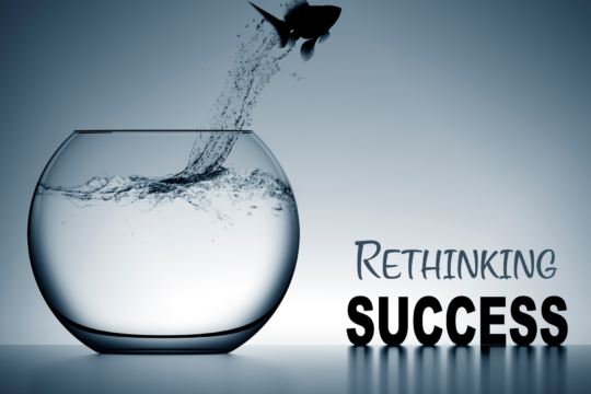Fish jumping out of a fishbowl to represent rethinking success